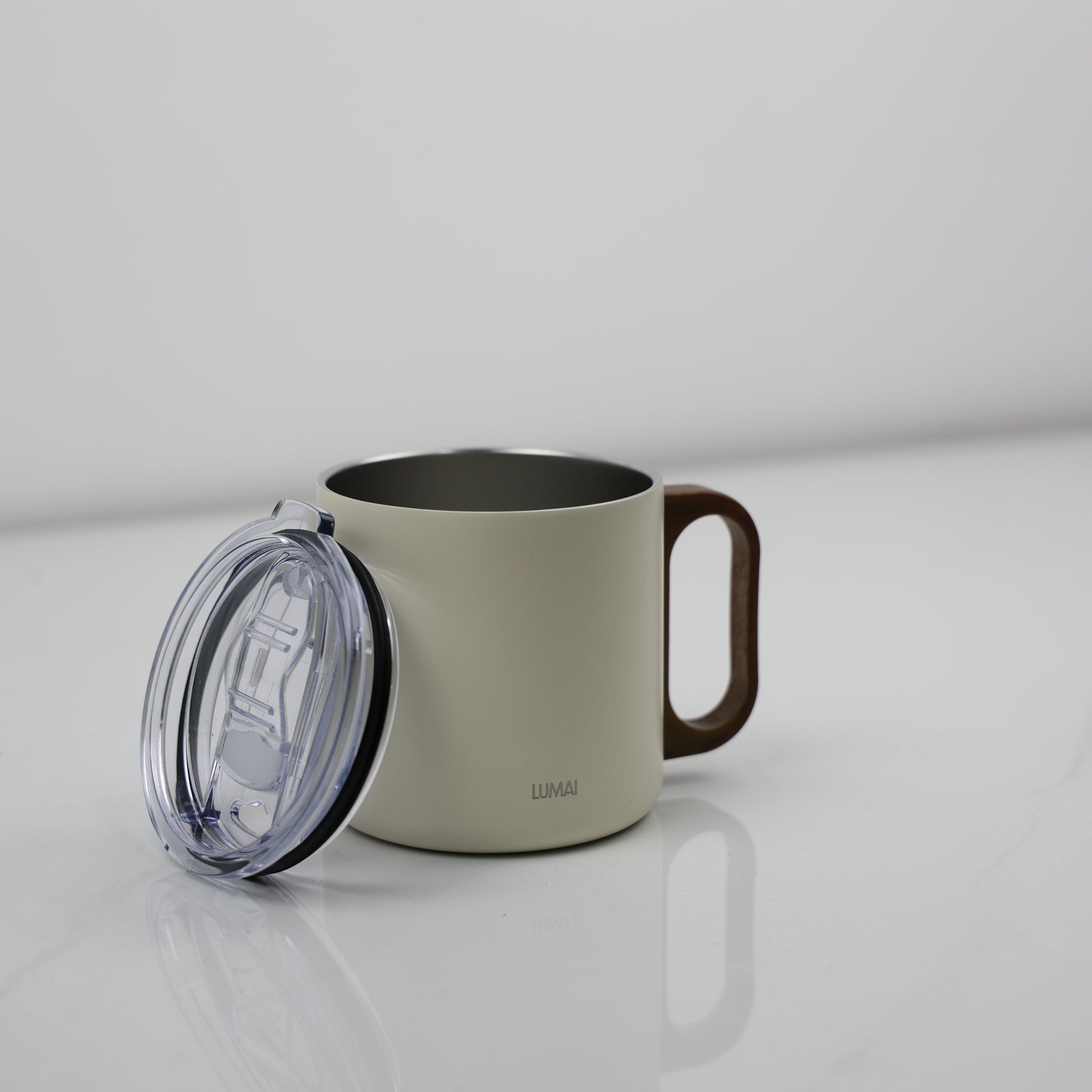 Caneca térmica off-white com tampa removida ao lado, revelando interior em aço inox e alça de acabamento madeira