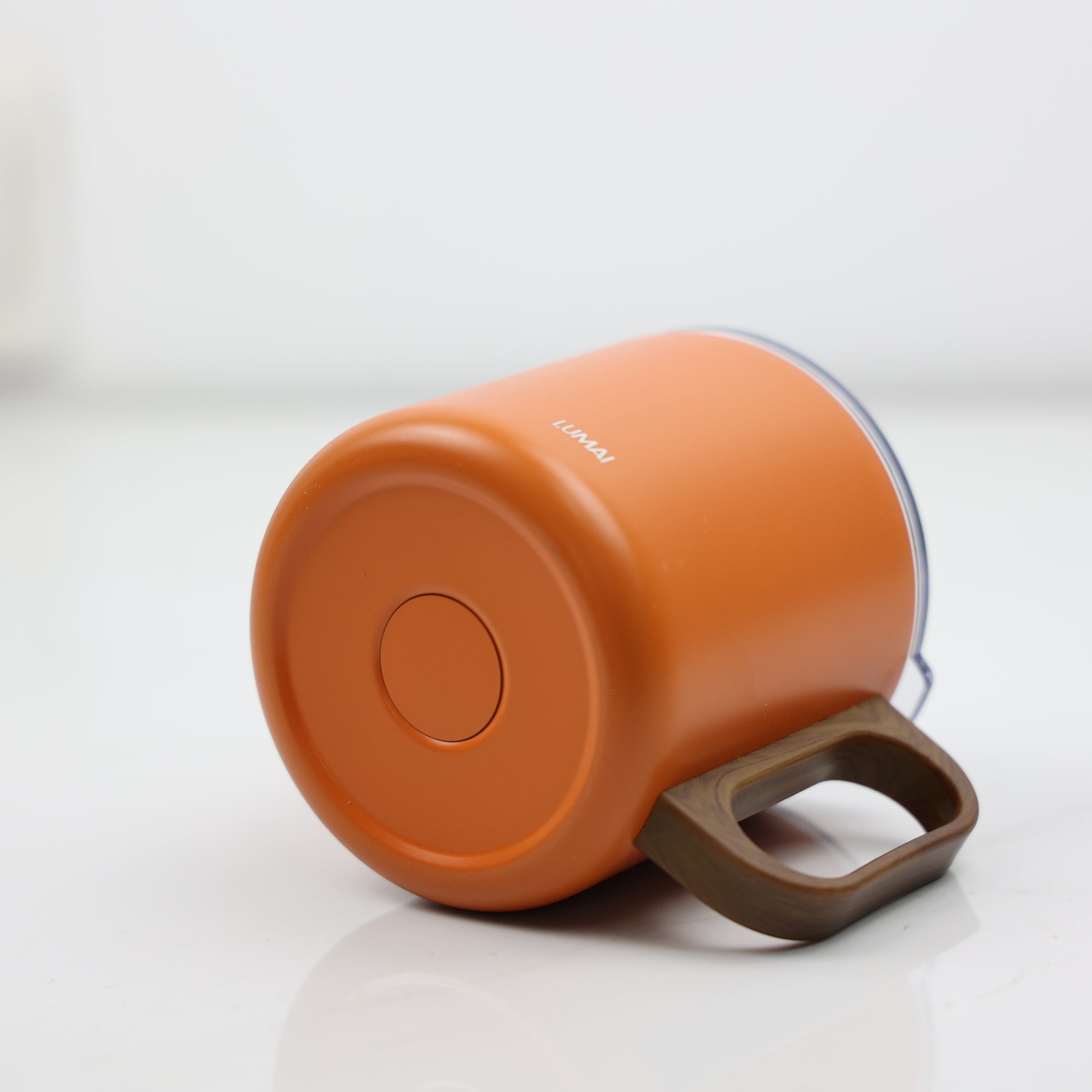 Ângulo inferior da base laranja da caneca com alça amadeirada em perspectiva deitada