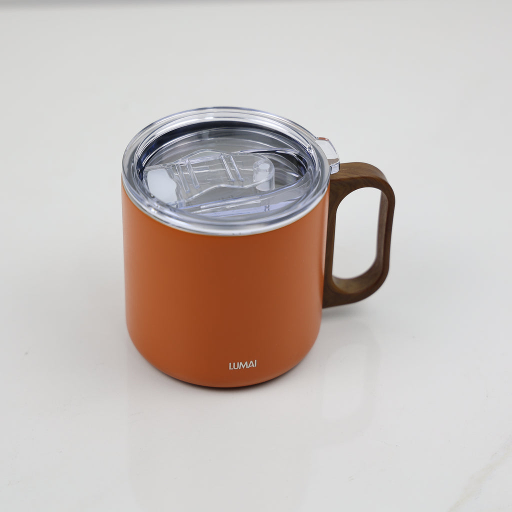 Tampa hermética transparente aberta mostrando mecanismo de vedação com caneca laranja ao fundo