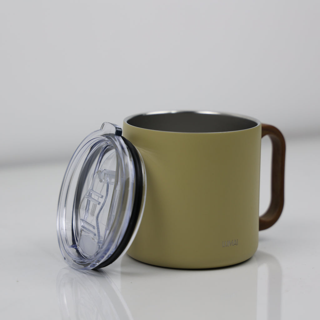 Caneca térmica amarela aberta com tampa transparente ao lado, mostrando interior em aço inox escuro