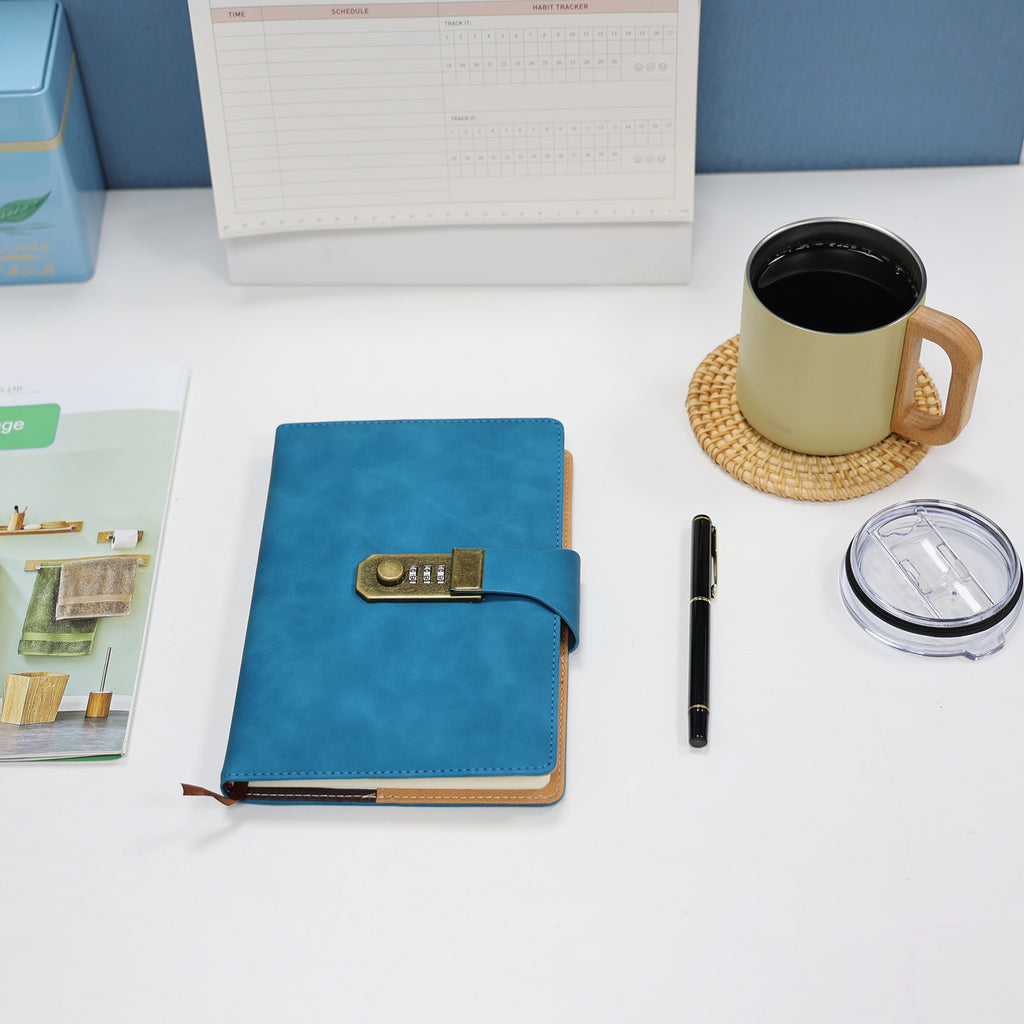 Foto lifestyle do Caderno com Cadeado Cartagena LUMAI azul sobre mesa com caneta e caneca, em ambiente de escritório.