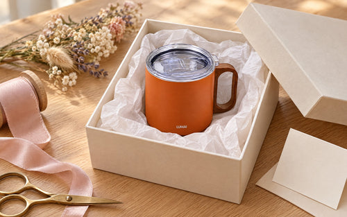 Caneca Caraíva laranja dentro de uma caixa de presente aberta