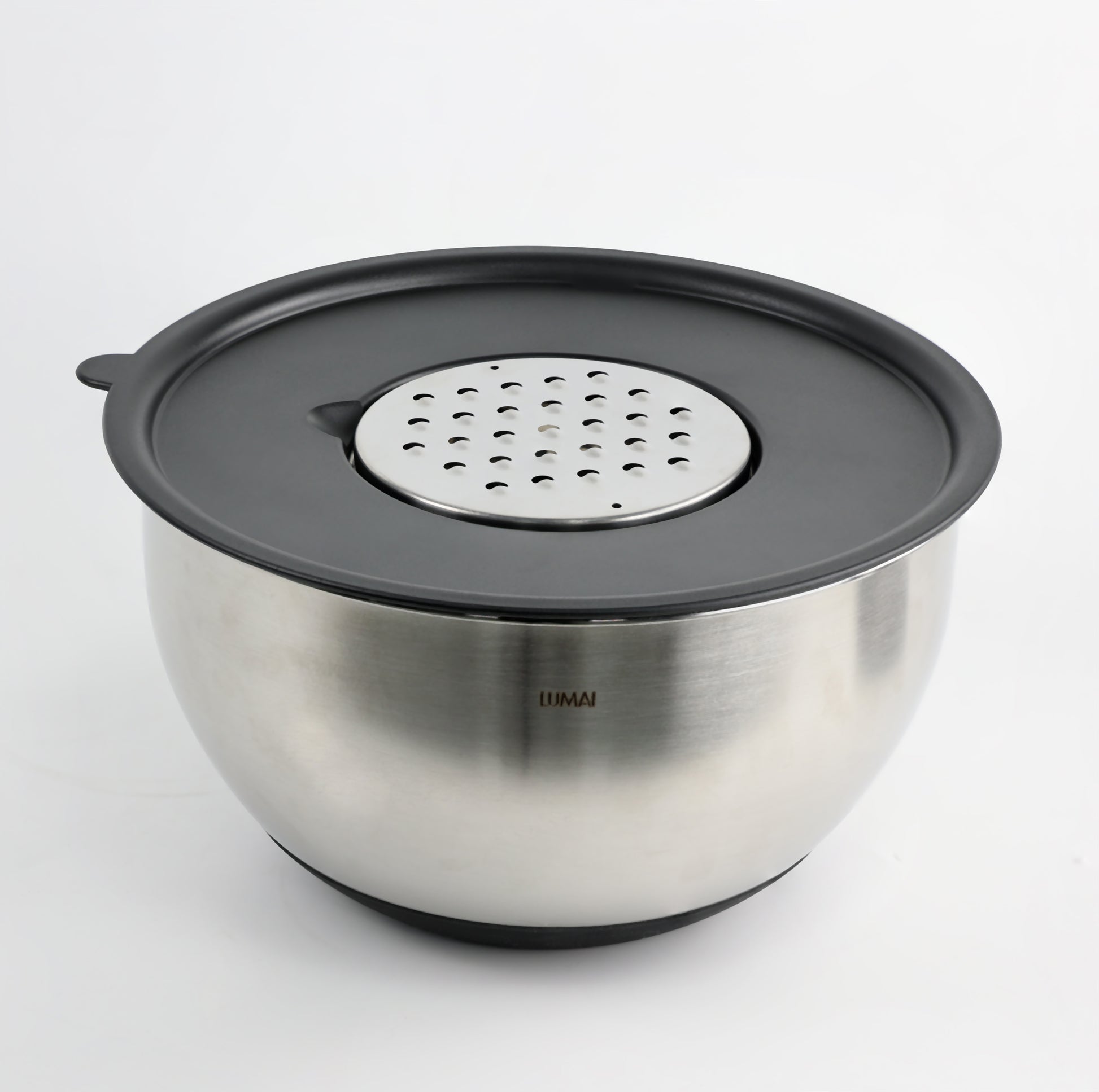 Close-up da Tigela de Inox LUMAI com tampa preta e disco ralador encaixado, mostrando a qualidade do aço inoxidável e o logo da marca.